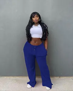 Detailed view of high-waisted blue wide-leg drawstring trousers on a model in street style