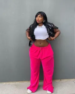 Detailed view of fashionable bright pink plus size wide-leg trousers with side slits