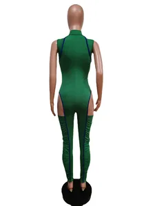 Back view of green slim-fit jumpsuit with hip cutouts and pleated leggings detail.
