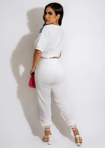 Back view of a white two-piece casual jogger set with denim patchwork details