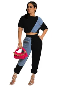 Two-piece black and denim patch crop top and jogger set shown on professional model