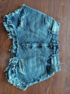 Detailansicht von blauen Denim-Shorts mit Destroyed-Effekten und ausgefransten Säumen.