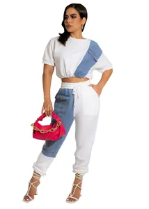 Detailed view of a white two-piece casual jogger set with blue denim patchwork accents.