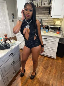 Detail view of a black polka dot halter neck romper with front cut-out design.
