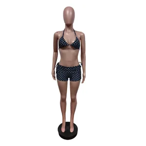Set bikini a pois tre pezzi con top allacciato al collo e shorts su manichino