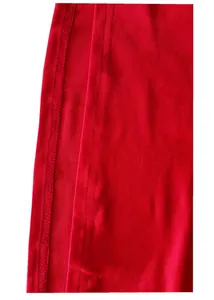 Dettaglio della texture del tessuto rosso e cuciture rinforzate sulla tuta casual