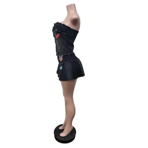 Seitenansicht des schwarzen trägerlosen Schlauch-Tops und des Faltenrock-Sets