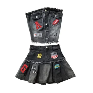 Zweiteiliges dunkelgraues Denim-Set mit Tube-Top und Faltenrock sowie coolen Aufnähern.