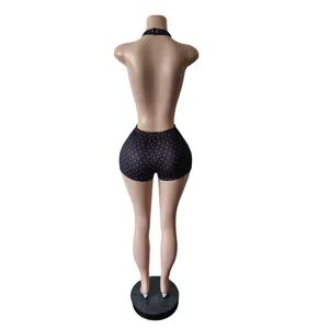 Back view of black polka dot halter backless romper on mannequin