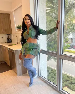 Model wearing a green spray-painted denim skirt set in a modern kitchen setting