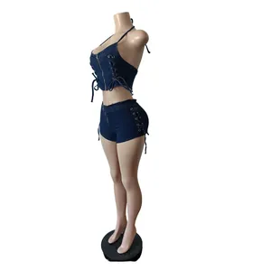 Vista lateral del conjunto de dos piezas en denim azul oscuro con cordones y cremalleras.