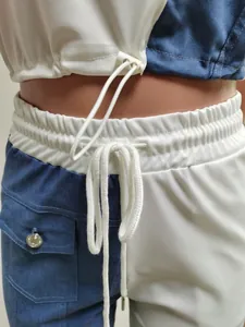 Detailed view of the elastic drawstring waist and pocket on a two-tone denim sports set