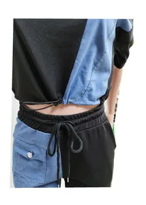 Detail view of color-block denim casual set featuring drawstring crop top and matching pants