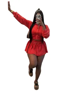 Rotes zweiteiliges Baumwollset mit bauchfreier Zip-Jacke und passendem Minirock.