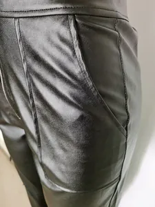 Detailopname van zwarte kunstlederen cargobroek met zak en hoogwaardige textuurweergave