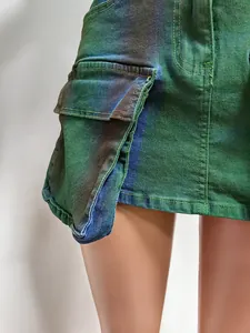 Detail view of green spray paint denim cargo mini skirt showing the large side pocket