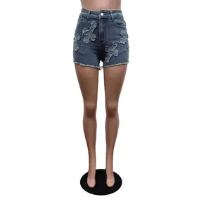 Vue détaillée d'un short en jean extensible bleu avec croix brodées et ourlets effilochés