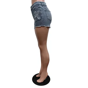Vue latérale d'un short en jean taille haute bleu avec broderie croix et ourlet effiloché