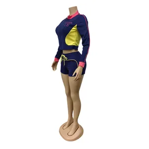 Ensemble de sport bleu marine deux pièces avec détails roses et jaunes, veste et short