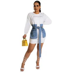 Detailed view of women's denim patchwork dress with embroidered text and belt accent