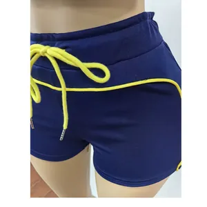 Gros plan sur un short de sport bleu marine avec cordon et liseré jaunes