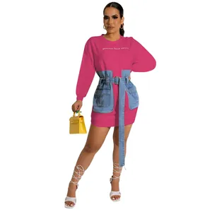 Detail of pink long sleeve dress featuring denim corset overlay and letter embroidery