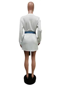 Back view of a white long-sleeved dress with a blue denim tie belt on a mannequin