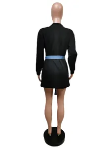 Back view of a black long-sleeve dress with a blue denim waist tie on a mannequin.