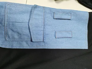 Detailed view of light blue denim patchwork featuring functional pocket on black dress