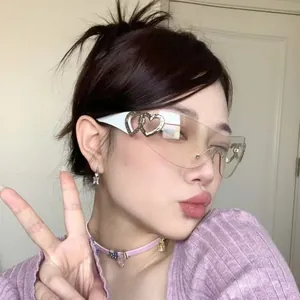 Detail shot of Y2K style rimless sunglasses featuring heart cutouts on a stylish Asian model