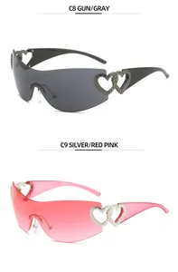 Detail view of Y2K rimless sunglasses with hollow heart temples in gray and pink.