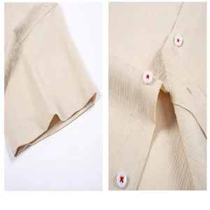 Detailweergave van herenoverhemd met golvende textuur en rode stiksels op knopen.