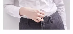 Gros plan d'une chemise blanche en fibre de bambou infroissable dans un pantalon gris.
