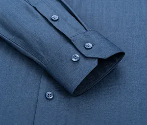 Détail de la manchette incurvée et des coutures précises d'une chemise bleue pour hommes