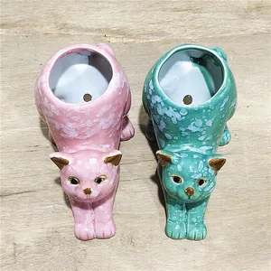 Detailansicht von zwei niedlichen Katzen-Keramik-Sukkulenten-Töpfen in Rosa und Blaugrün