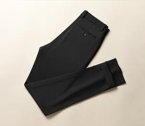 Close-up view of black slim-fit business trousers for men on a neutral background