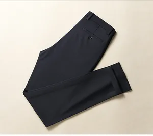 Detailed top view of folded navy blue business trousers on a textured cream base.