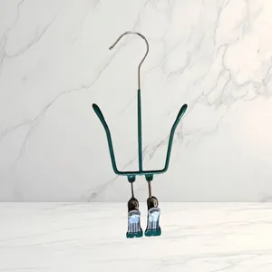 Detailed close-up showing the green coated frame and metal clips of the shoe drying rack