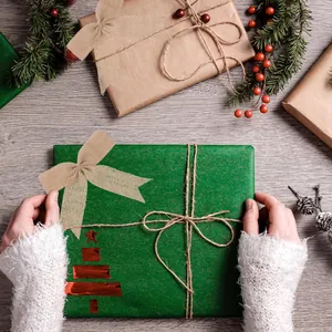 Fiocco in juta naturale fatto a mano per confezioni regalo di Natale su sfondo in legno