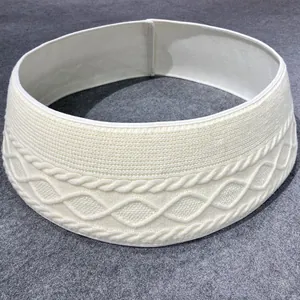 Close-up detail of a white cable-knit Christmas tree collar with elegant textured patterns