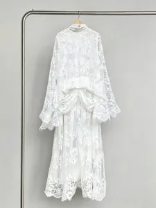 Detailed view of a white French lace dress with high neck and elegant bell sleeves