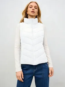 Detalle de un elegante chaleco acolchado blanco con cuello alto en una modelo