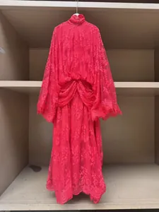 Detailed macro view showing the pink French lace dress featuring high neck and bell sleeves.