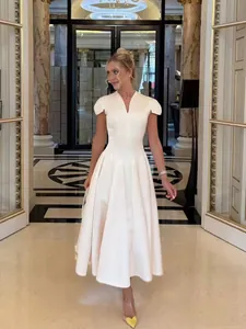 Detail view of an elegant cream V-neck flared midi dress featuring unique petal sleeves