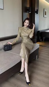 Elegant golden metallic pleated bodycon maxi dress worn by an Asian model in a luxury room