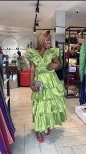 Close-up of a bright green pleated multi-layer ruffled evening dress worn by a model