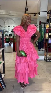Elegant tiered pink evening dress featuring dramatic ruffles and a stylish deep V-neckline.