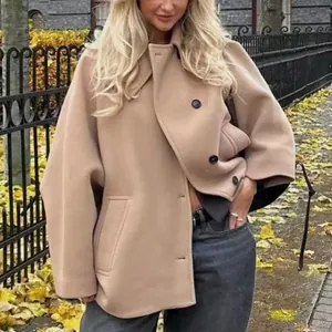 Vista detallada de un abrigo corto beige de estilo francés con mangas de capa y cuello de solapa