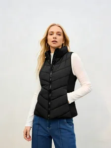 Waist-up view of a model wearing a black stand-collar quilted puffer vest for winter
