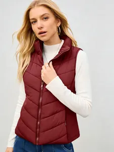 Detail view of a stylish wine red quilted puffer vest with a high stand collar and zipper
